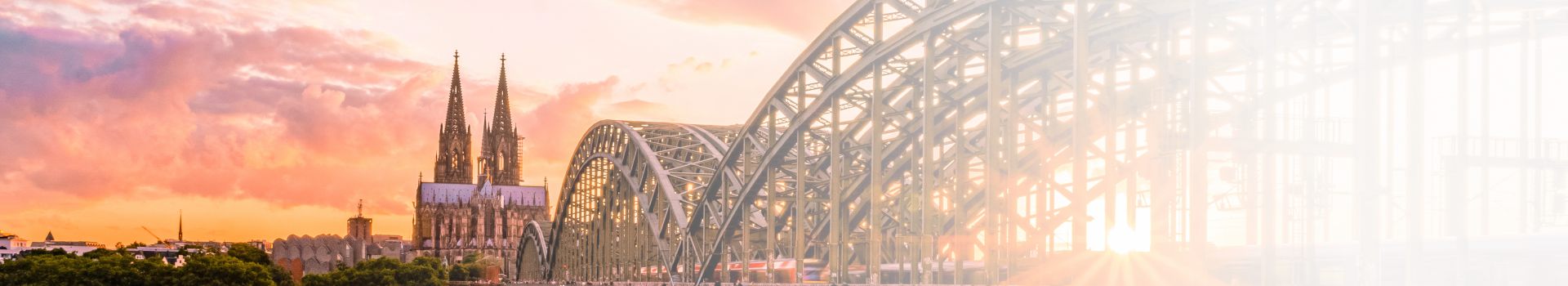Kölner Dom und Brücke überm Rhein bei Sonnenuntergang