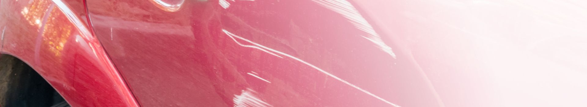 Kratzer an der Seitentür eines roten Autos. Kollision oder Unfall.