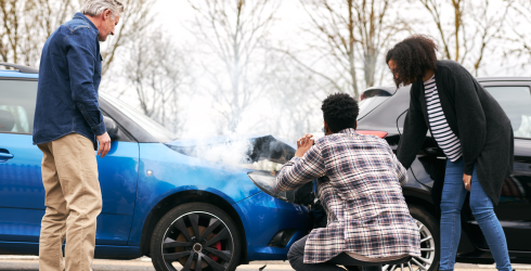 Junges Paar macht ein Bild vom Unfallschaden am Auto