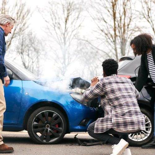 Junges Paar macht ein Bild vom Unfallschaden am Auto