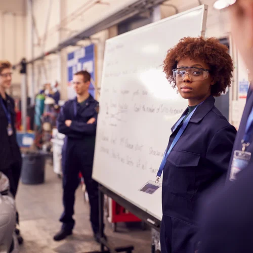 Leute die eine Schulung machen stehen vor einem Whiteboard